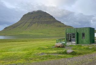 Mountain with a small green cabin in the foreground