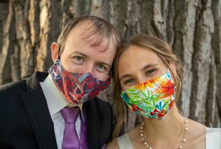 Stacy and Mike wearing wedding attire and face masks