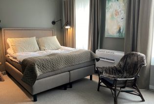 Bed and armchair in an upscale hotel room decorated in gray