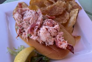 Lobster roll on a plate with kettle chips