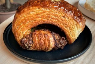 Pistachio croissant on a black plate