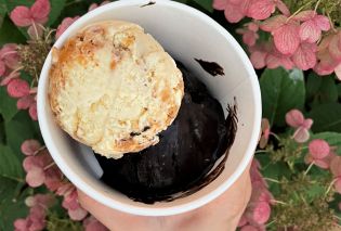 hand holding bowl with scoop of smoked peach crisp and s'more ice cream