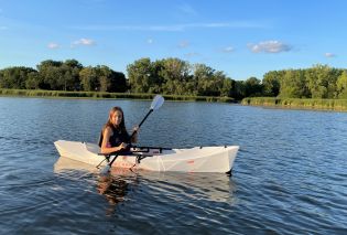 Stacy paddling Oru Lake Kayak on lake